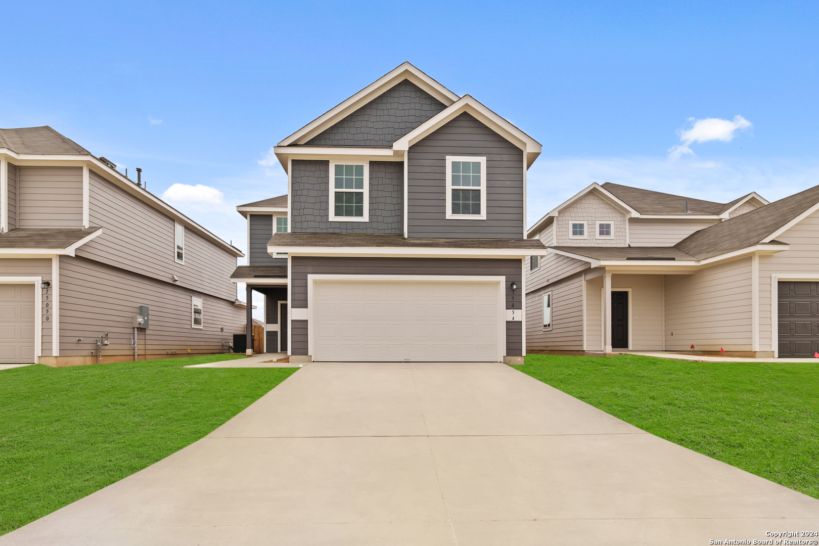 a front view of a house with a yard and garage