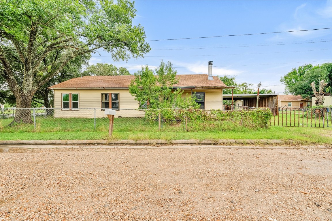 a front view of a house with a yard and potted plants