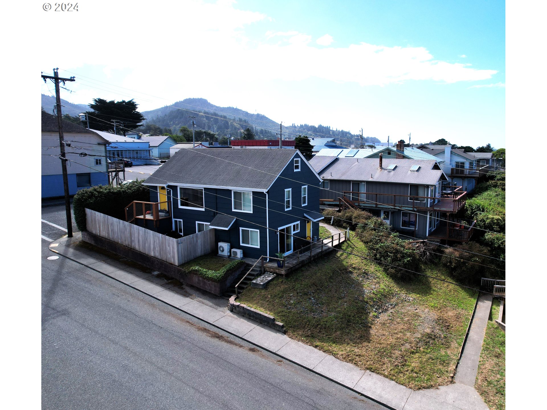 a view of a house with wooden deck and furniture