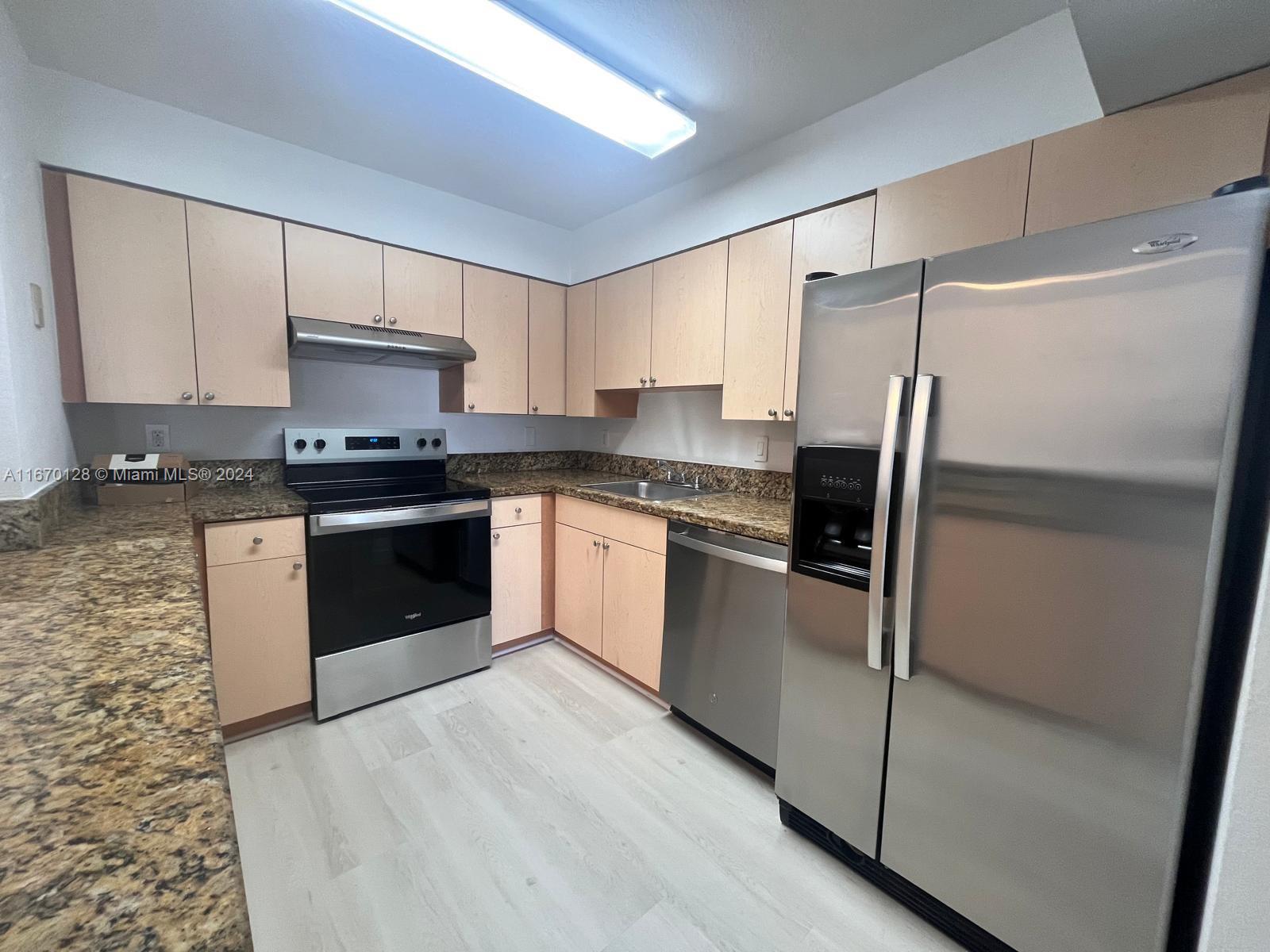 a kitchen with stainless steel appliances a refrigerator sink and cabinets