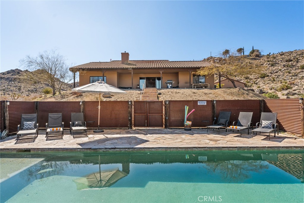 a view of a house with swimming pool and sitting area