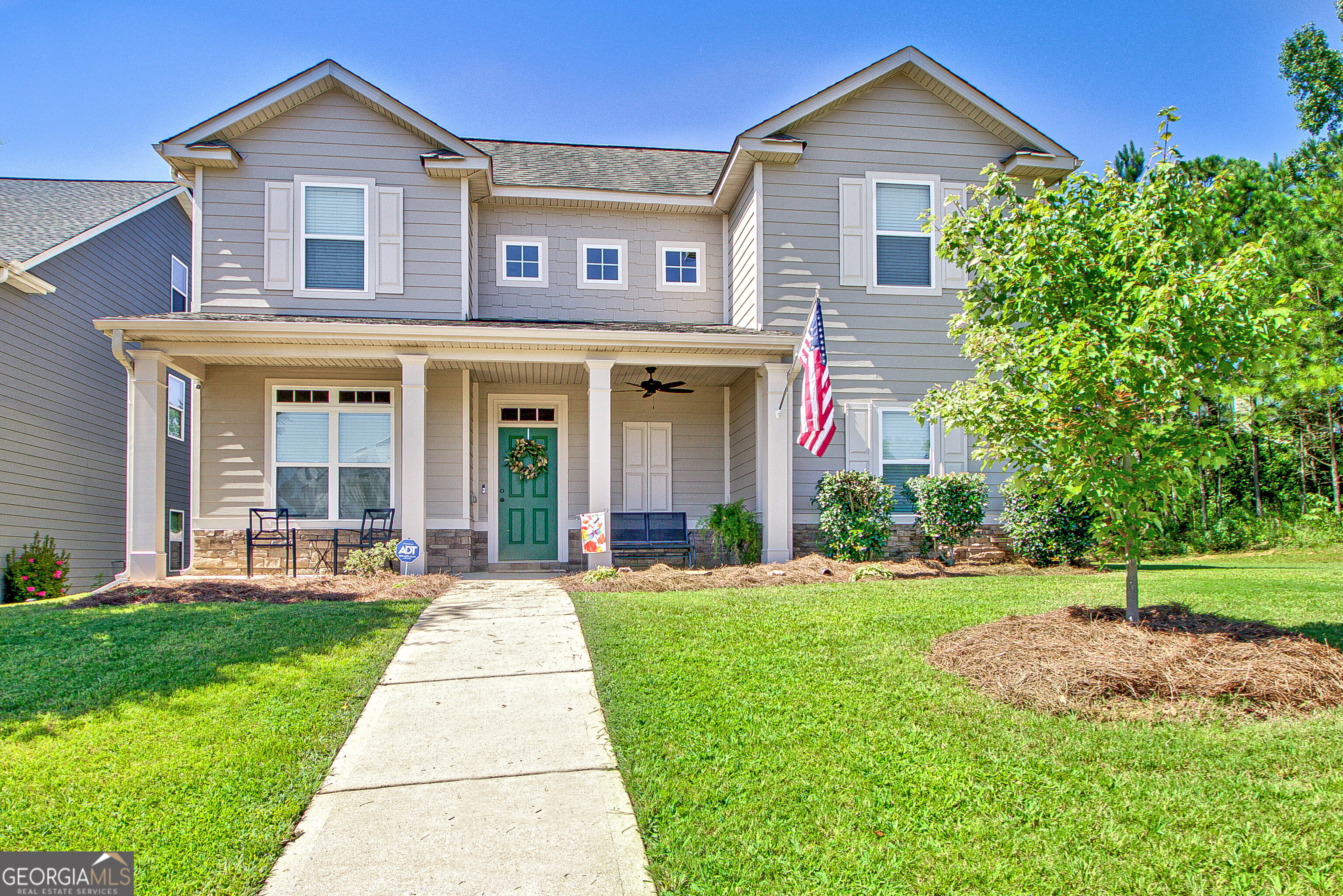 a front view of a house with a yard and potted plants