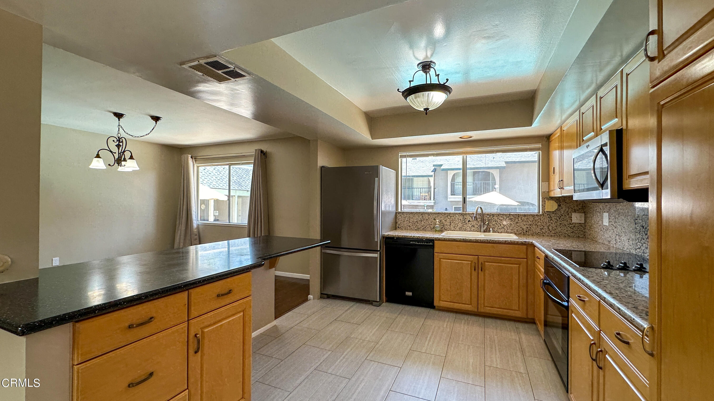 a large kitchen with stainless steel appliances granite countertop a stove sink and refrigerator