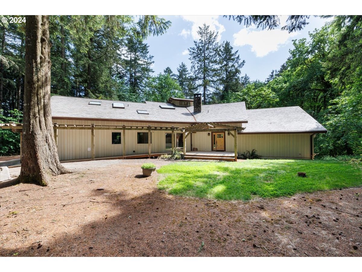 a front view of a house with a yard and trees