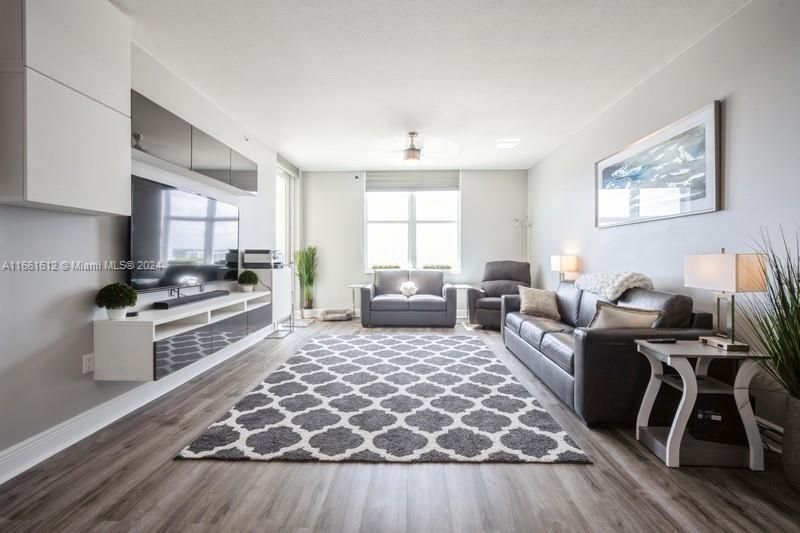 a living room with furniture and a wooden floor