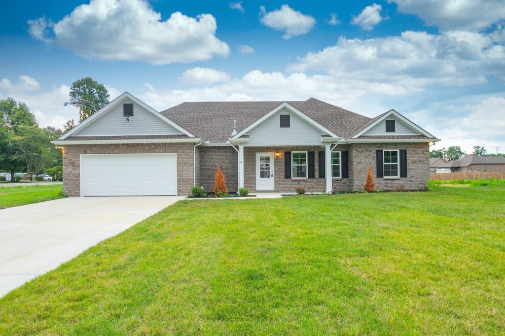 a front view of a house with a garden and yard