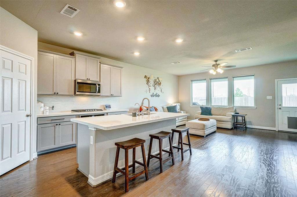 a large white kitchen with lots of counter space a sink appliances and dining table