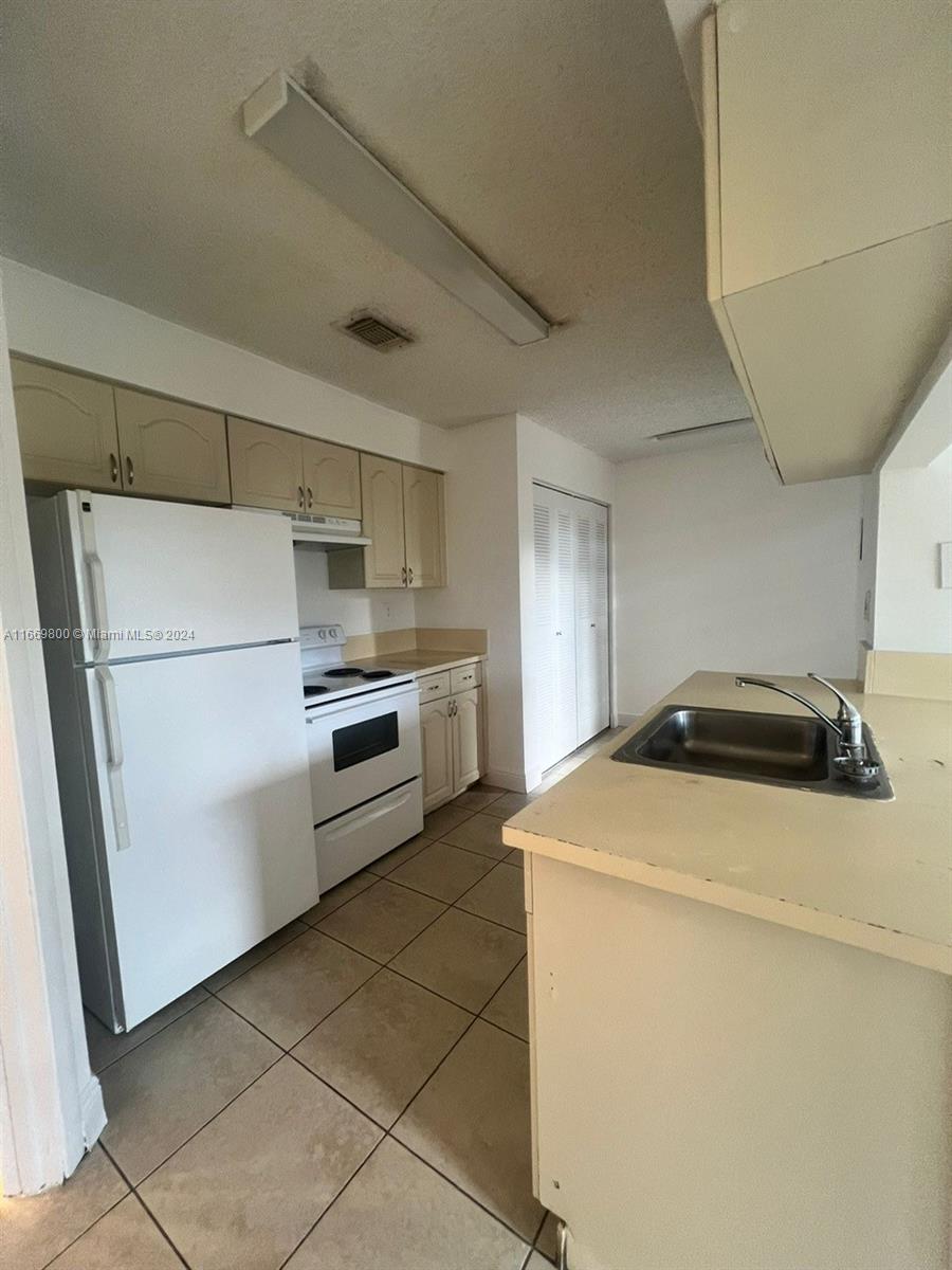 a kitchen with a stove top oven and refrigerator