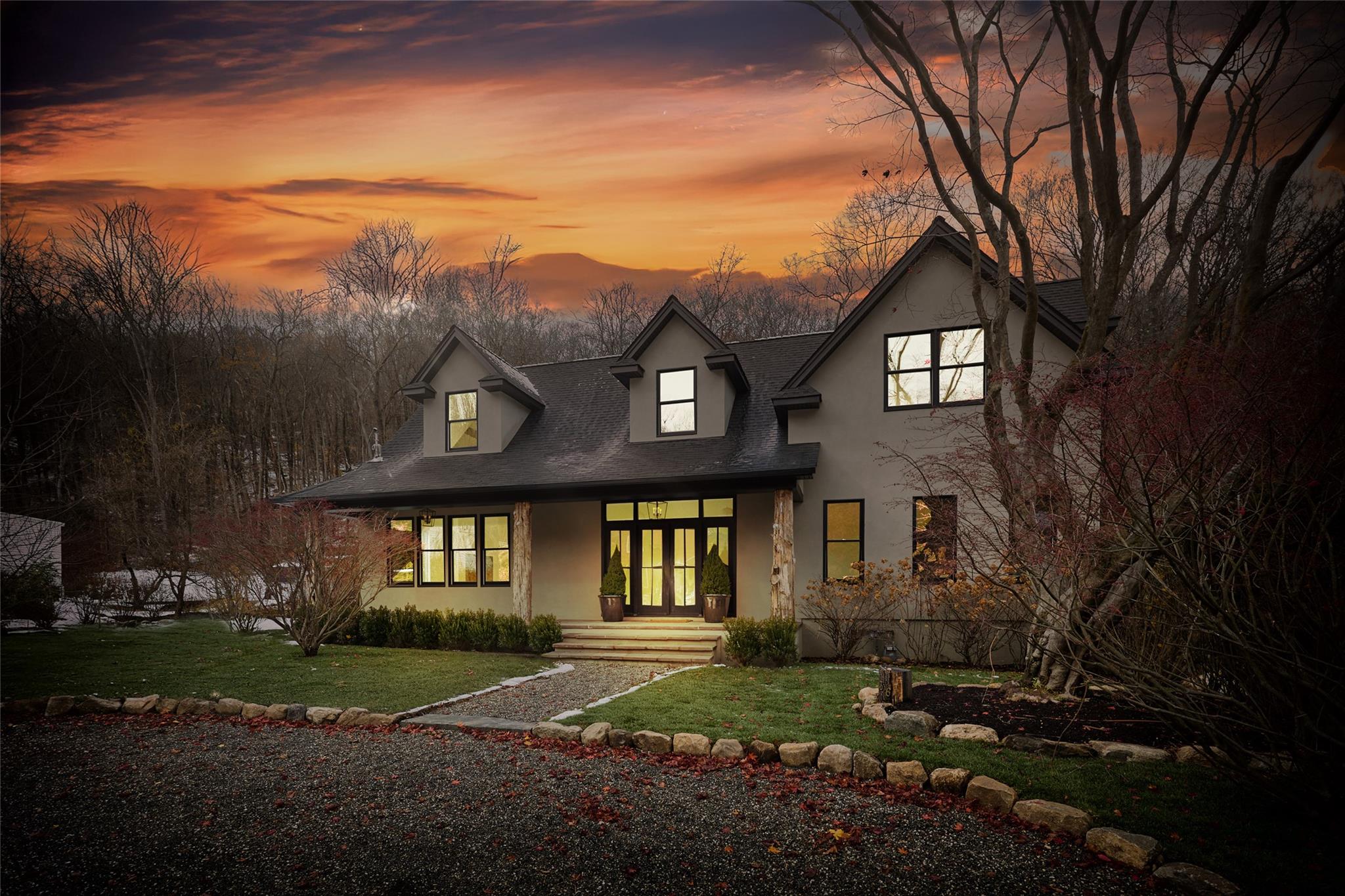 Back house at dusk featuring a yard and french doors