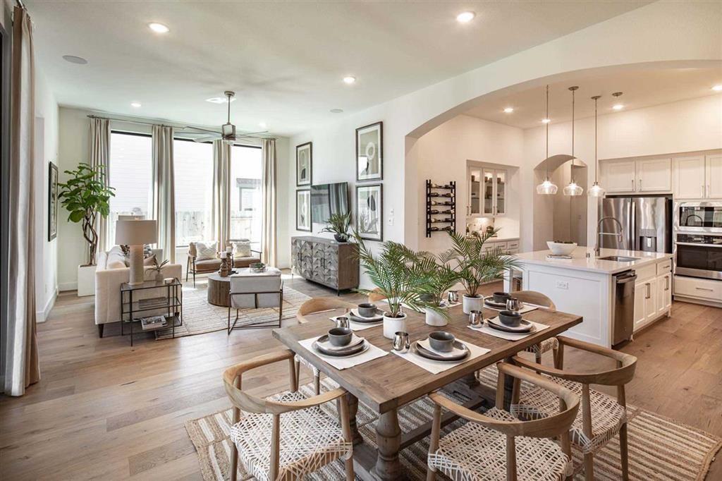 a view of a dining room and livingroom with furniture wooden floor a chandelier