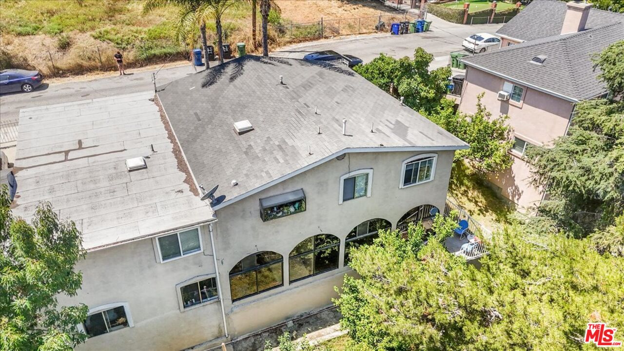 an aerial view of a house with a yard and large tree