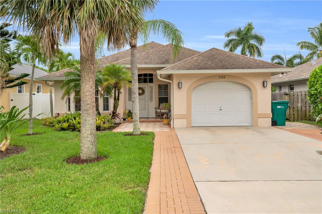 View of front of house with a garage and a front yard