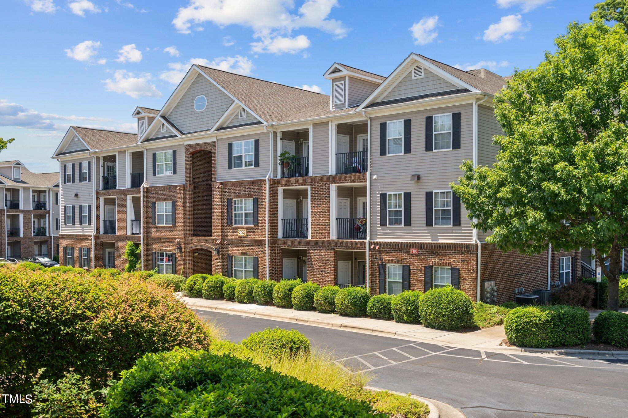 a front view of a residential apartment building with a yard