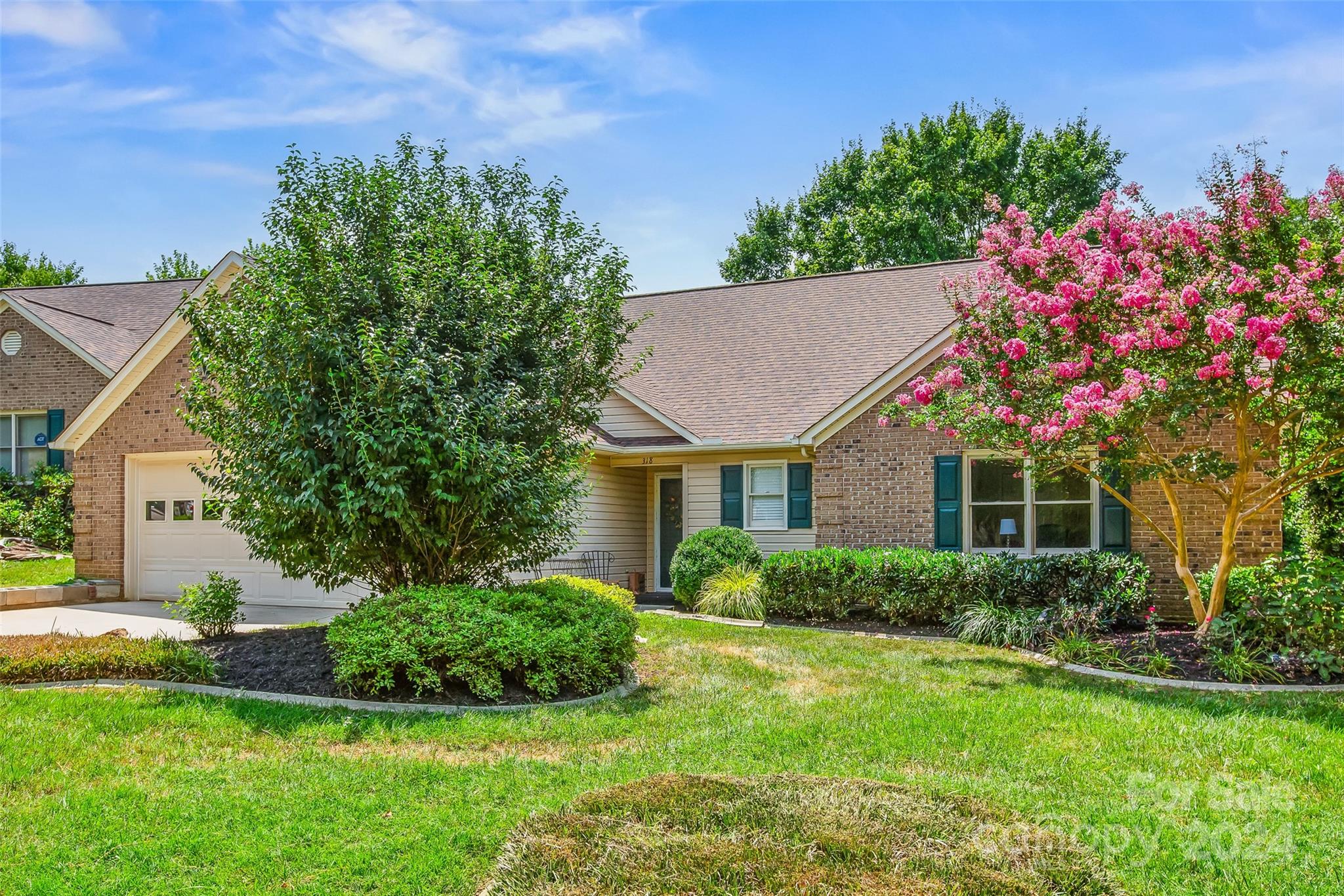 a front view of a house with a yard and potted plants