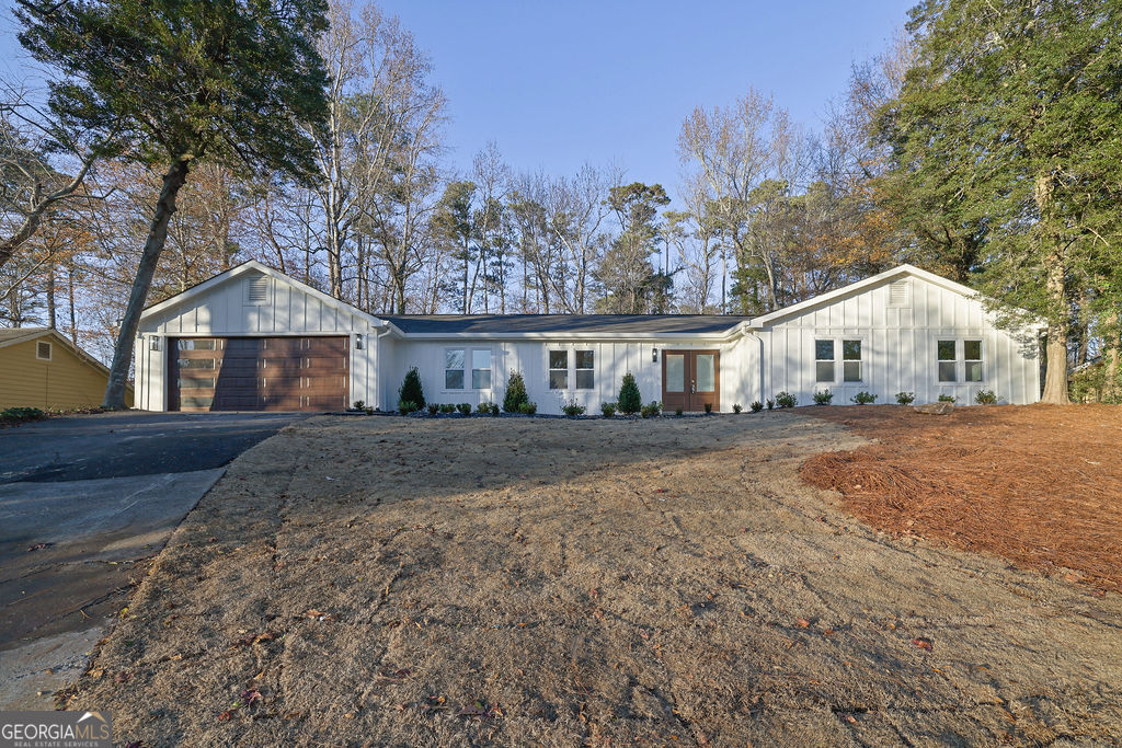 a front view of a house with a large trees