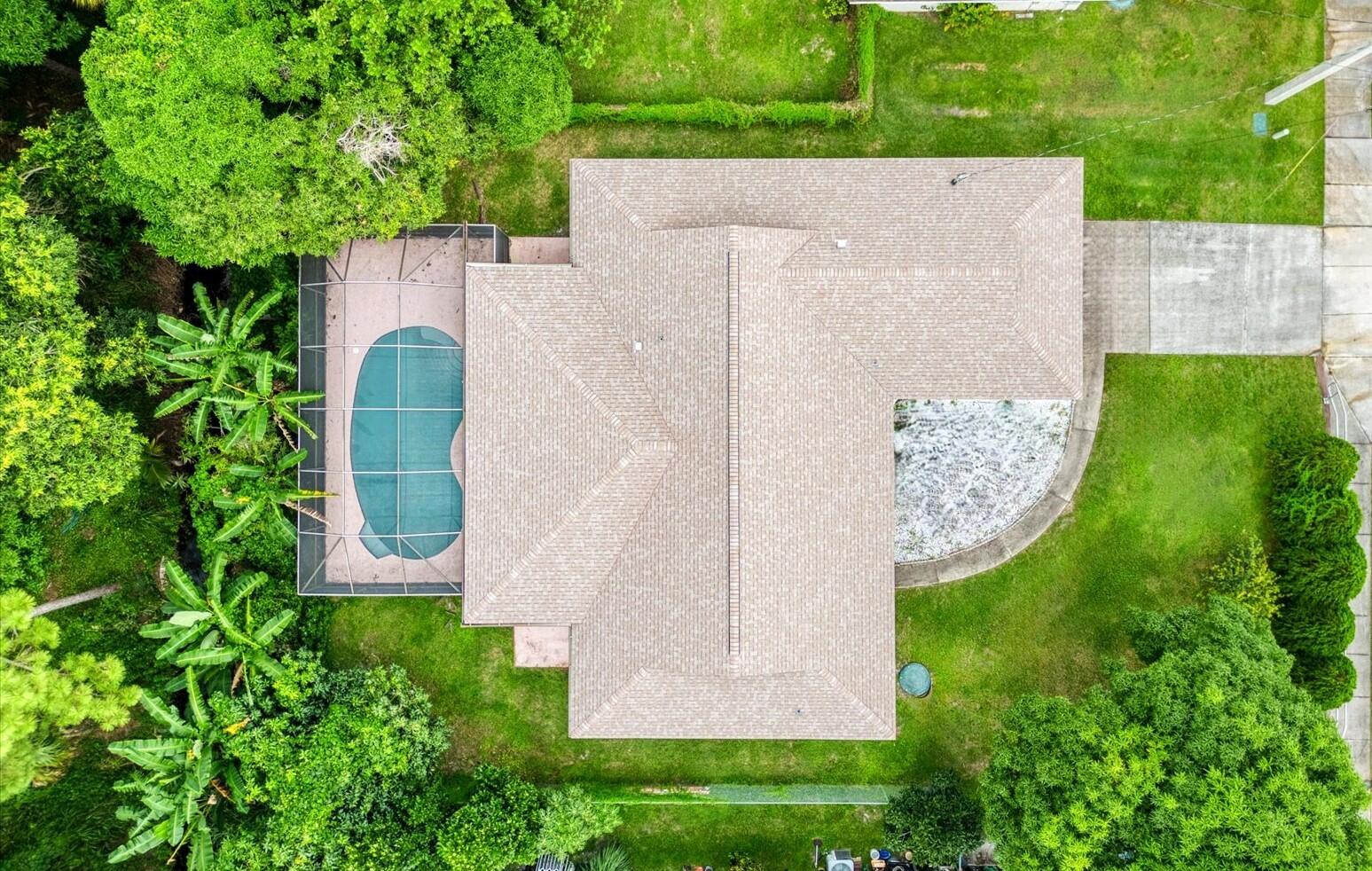 an aerial view of a house with a garden and trees