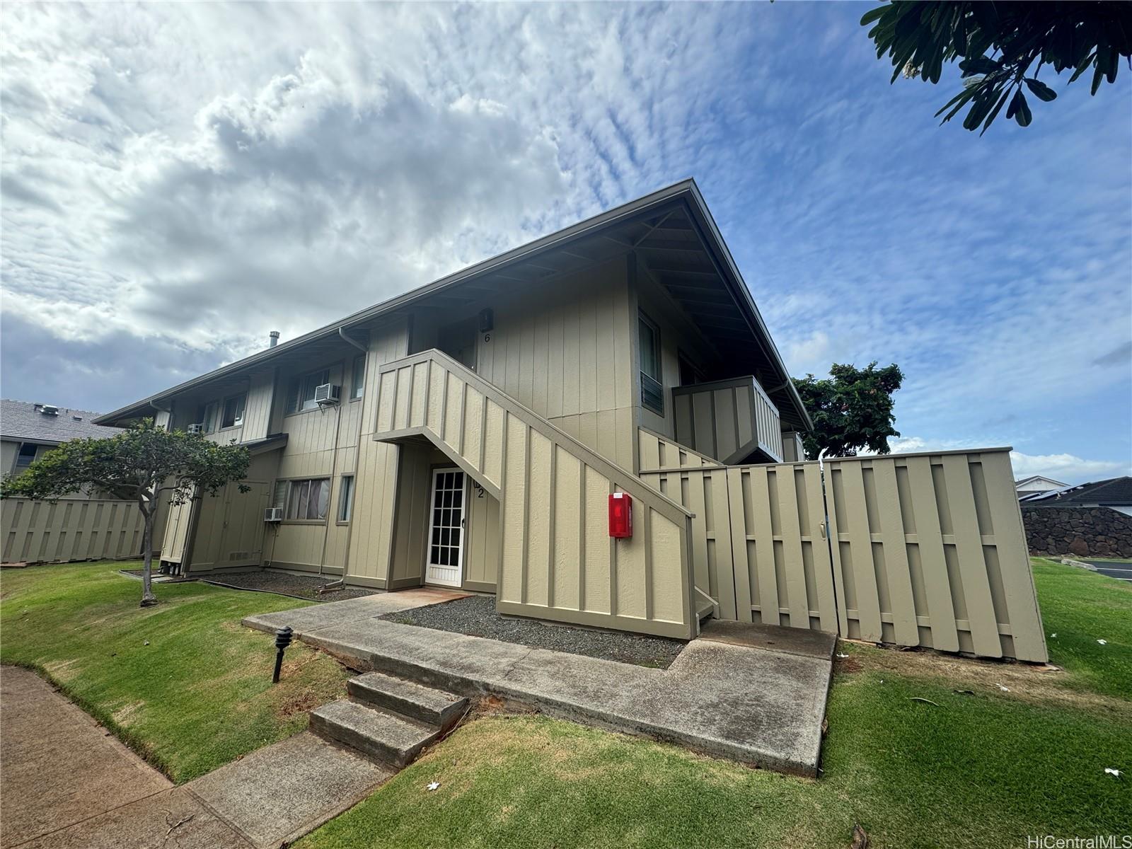 a view of house with backyard and wooden fence