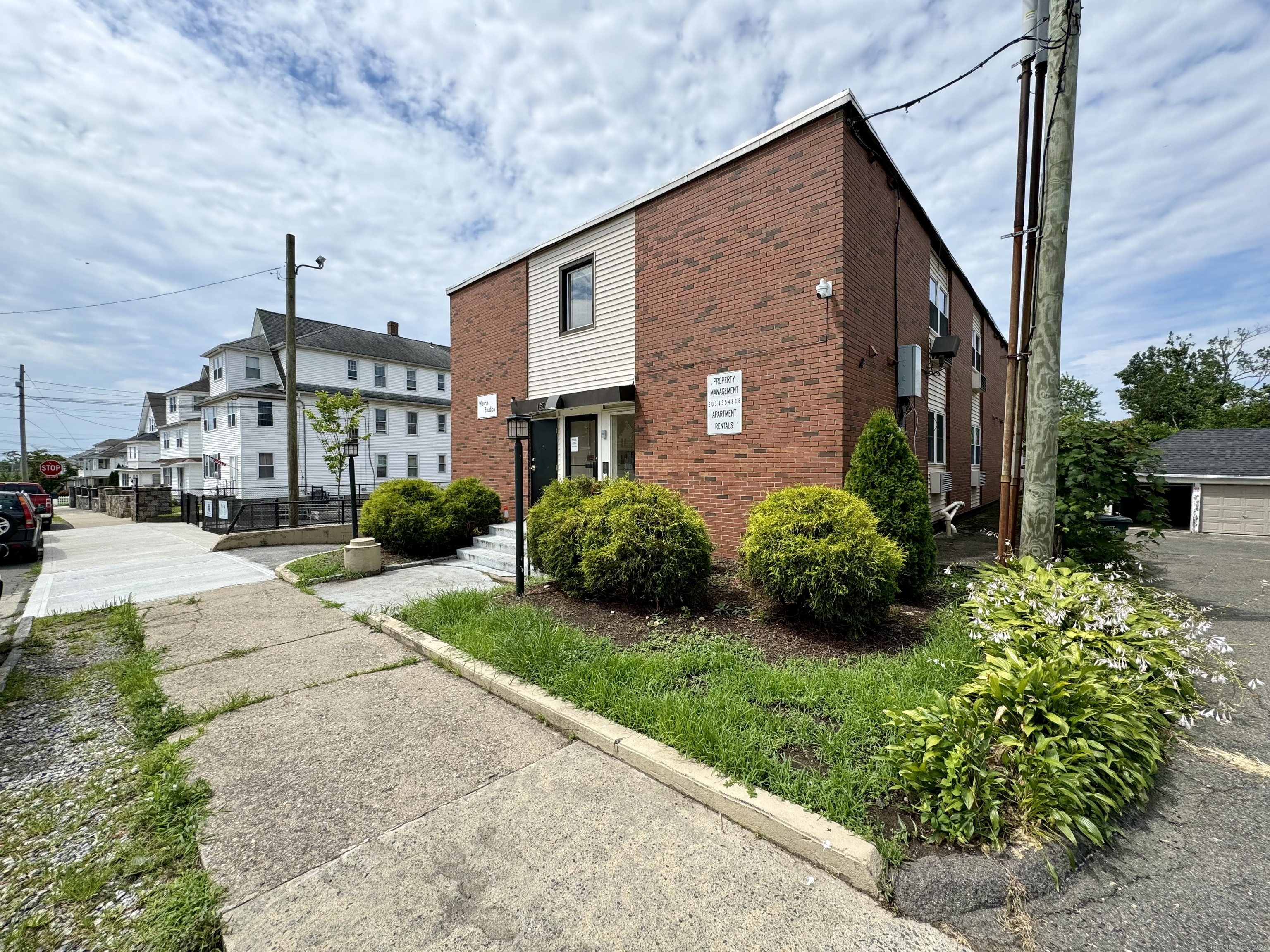 a front view of a house with a yard and potted plants