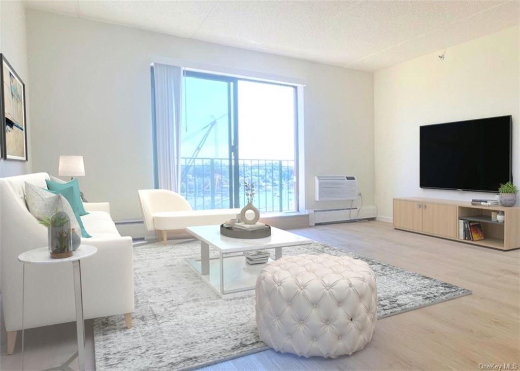 Living room featuring a textured ceiling, a baseboard radiator, a wall unit AC, and light hardwood / wood-style floors