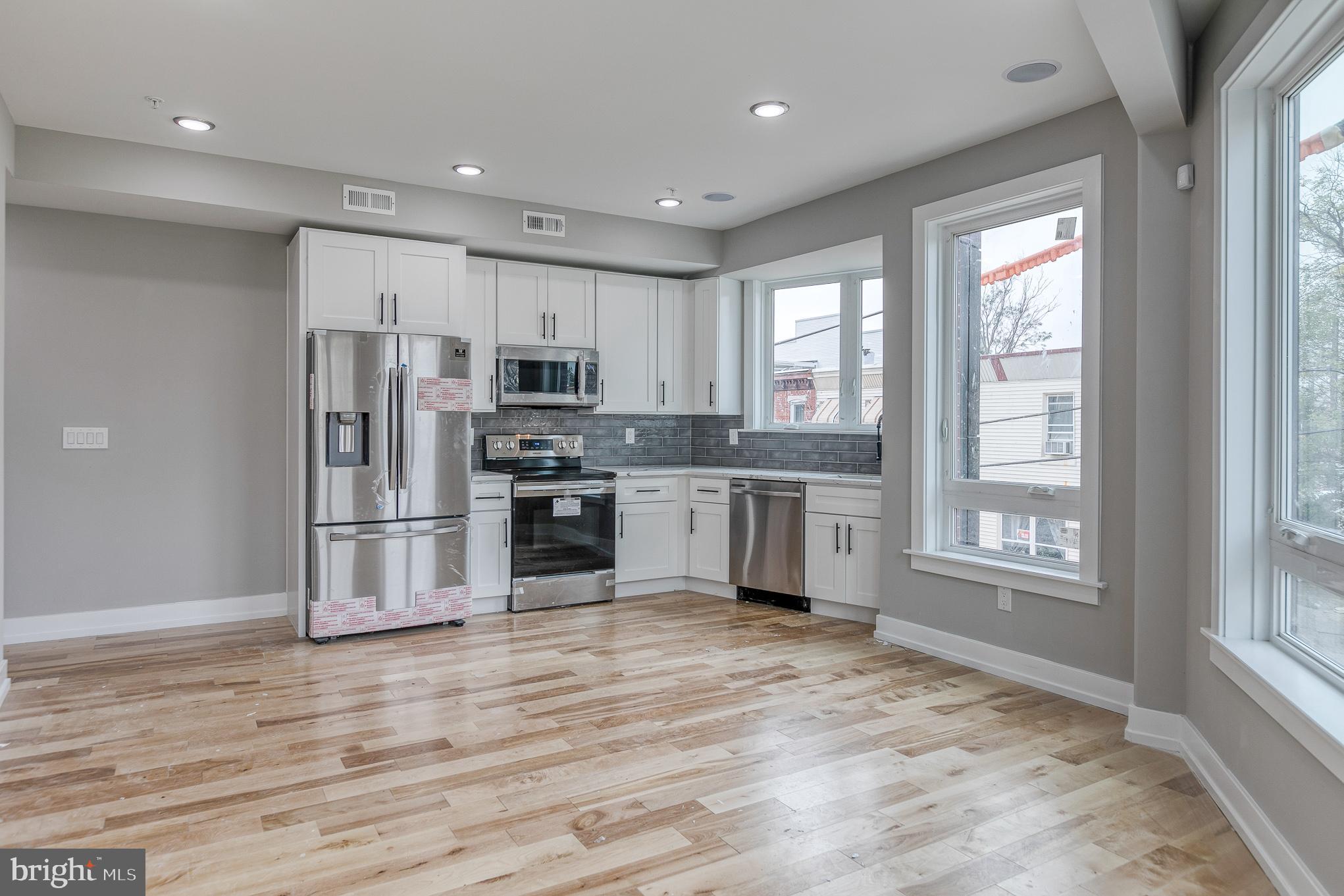 a kitchen with stainless steel appliances granite countertop a refrigerator and a stove top oven