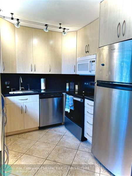 a kitchen with stainless steel appliances granite countertop a refrigerator and a stove