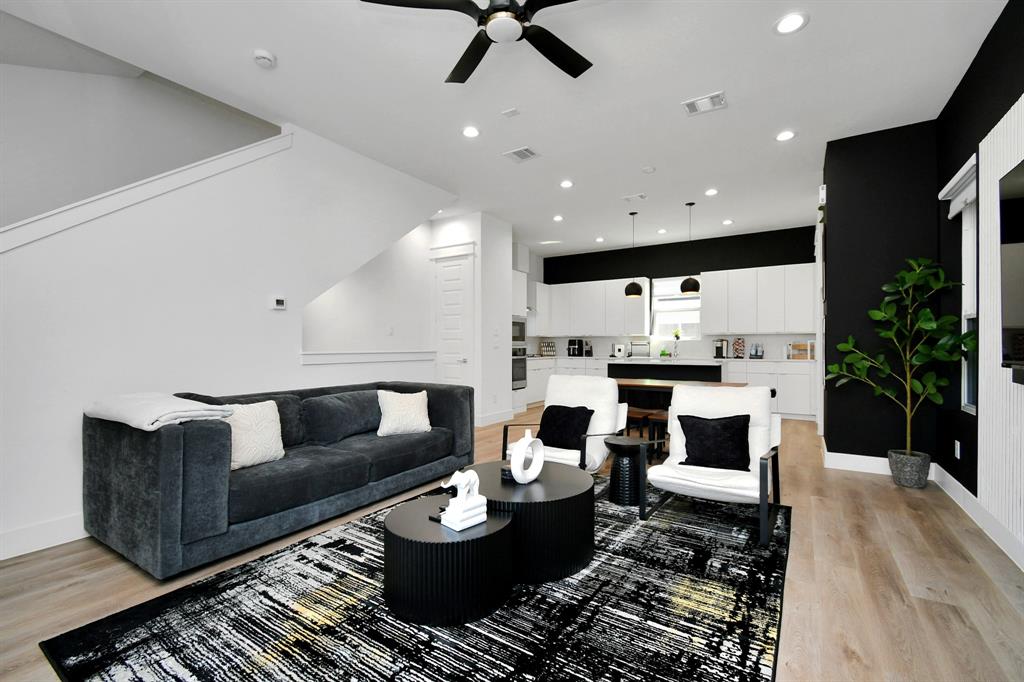 a living room with furniture and view of kitchen