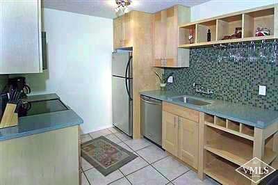 a kitchen with stainless steel appliances granite countertop a refrigerator and a stove