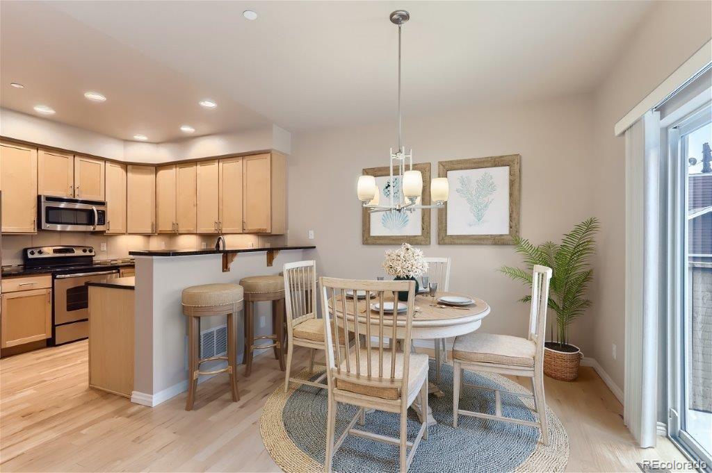 a kitchen with microwave a refrigerator and chairs