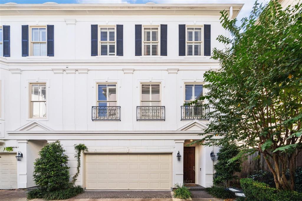 4303 Feagan St. Three-story, white stucco home with charming ironwork on the Juliet balconies, and a two-car garage with 2 additional parking spaces exclusive to this home.