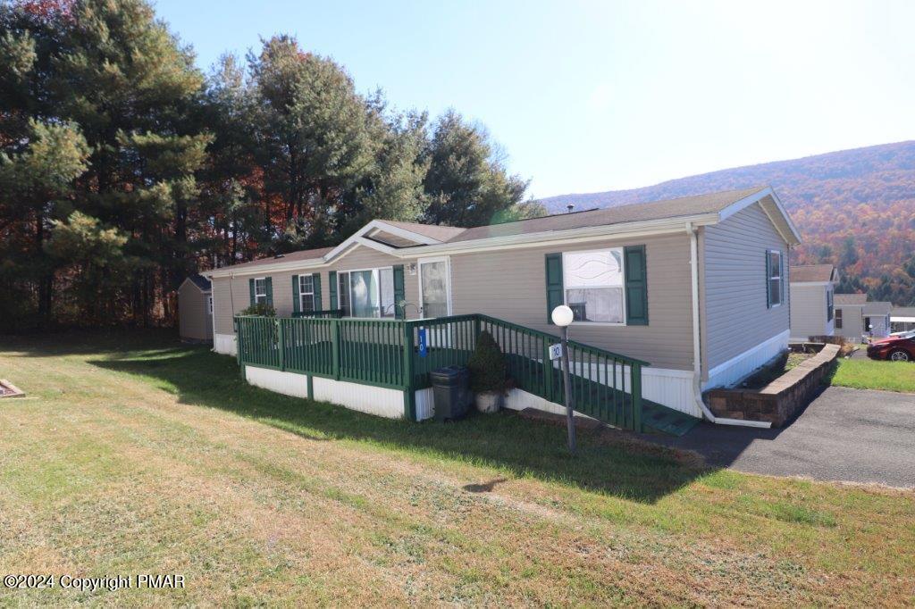 a view of a house with a yard porch and wooden fence