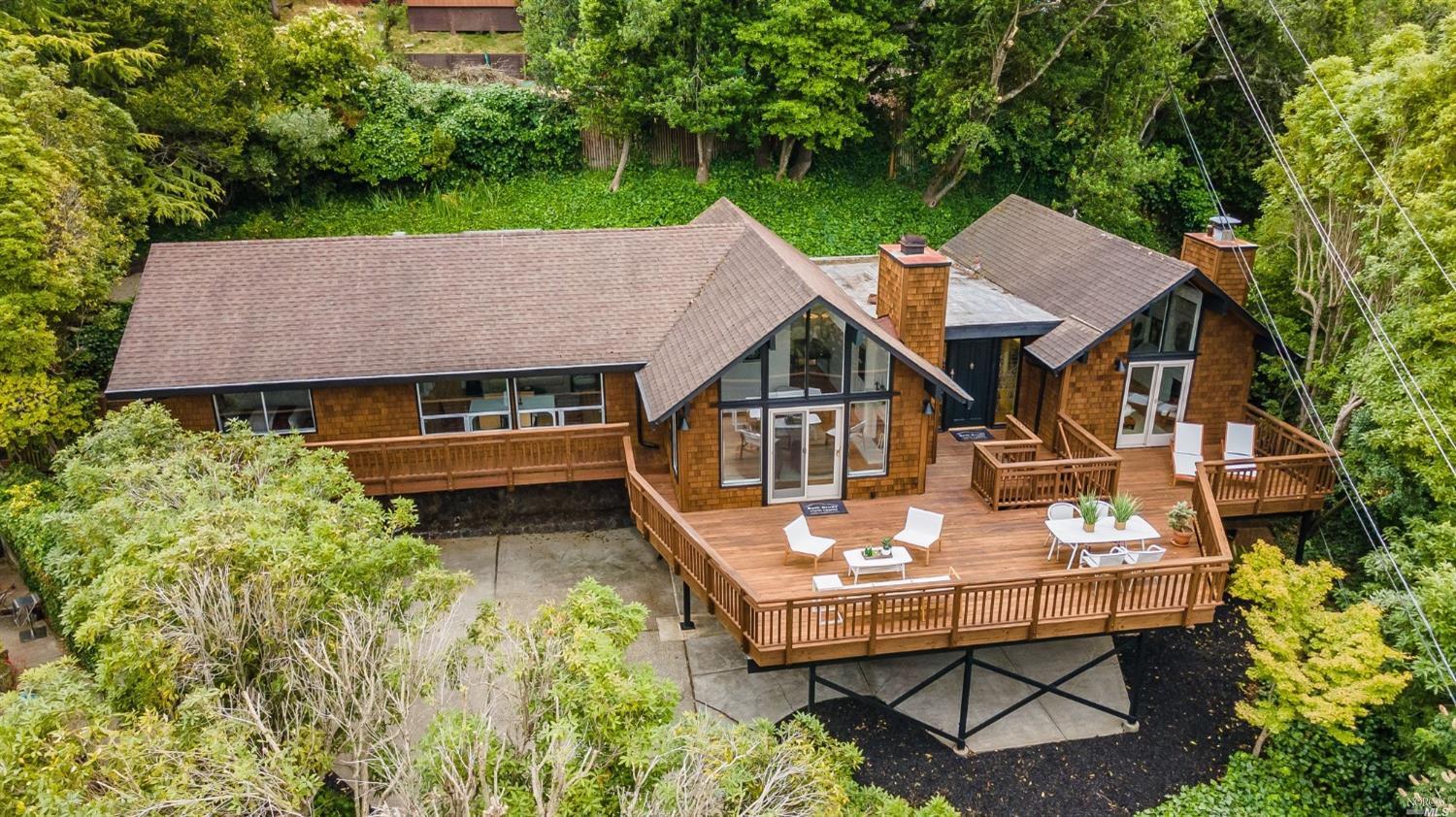 an aerial view of a house with table and chairs under an umbrella