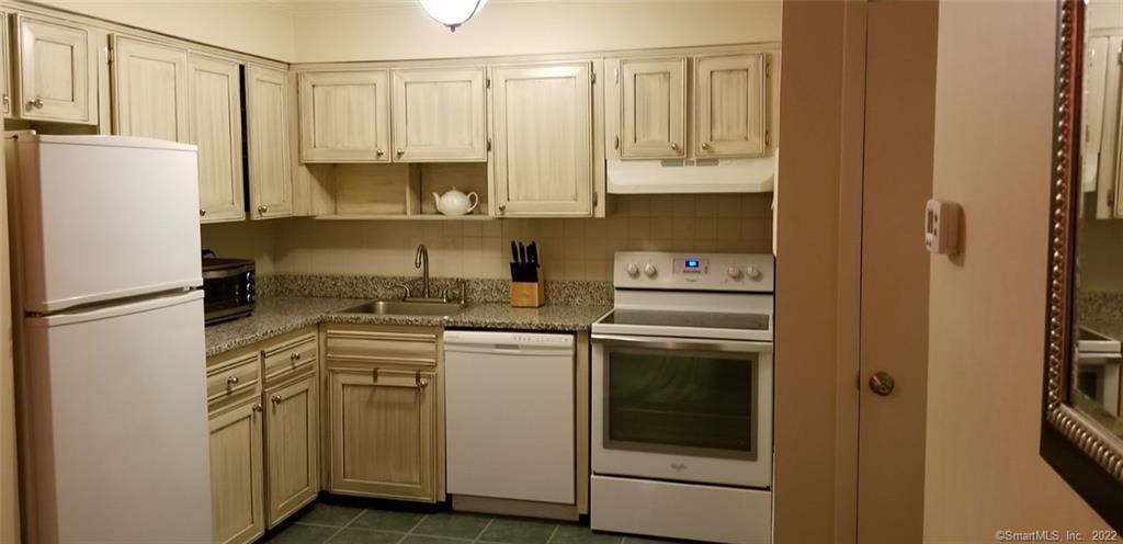 a kitchen with a refrigerator sink stove and cabinets