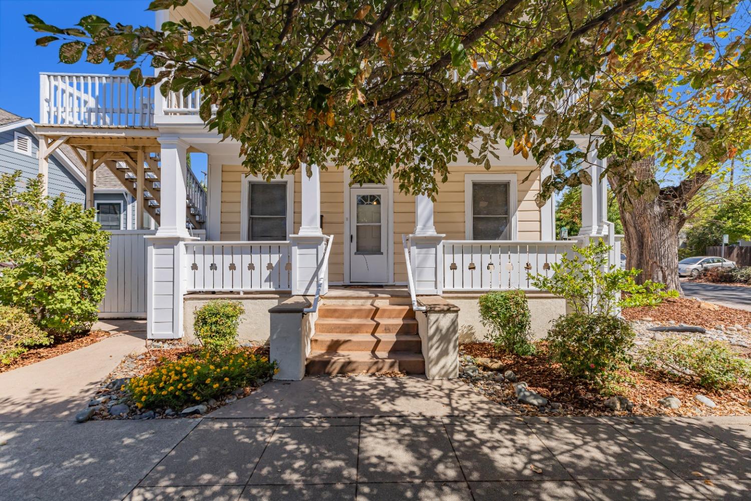 front view of house with a yard and potted plants