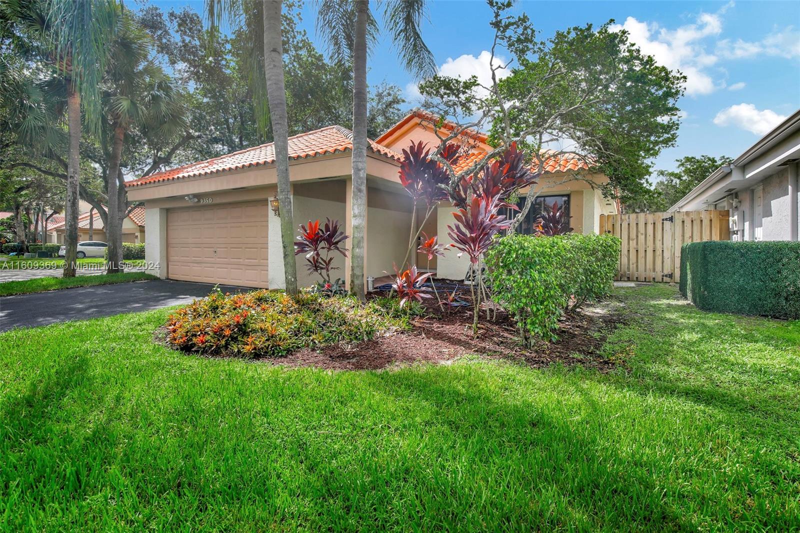 a front view of a house with a garden and plants