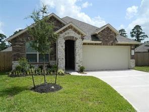 a front view of a house with a yard and a garden