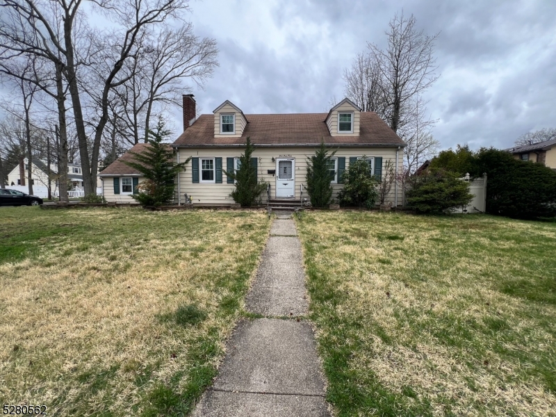 a front view of house with yard and trees around