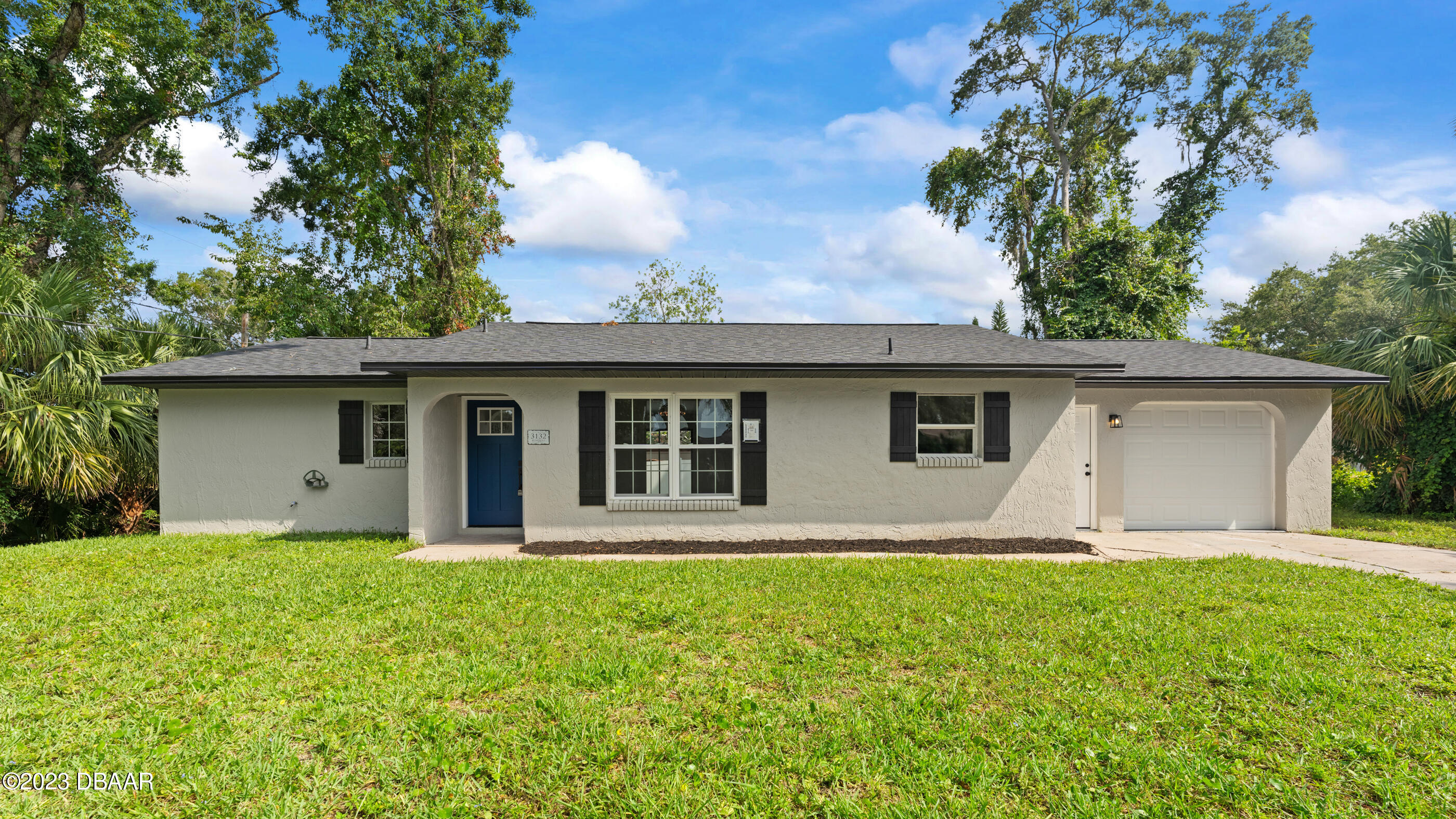 a front view of house with yard and trees