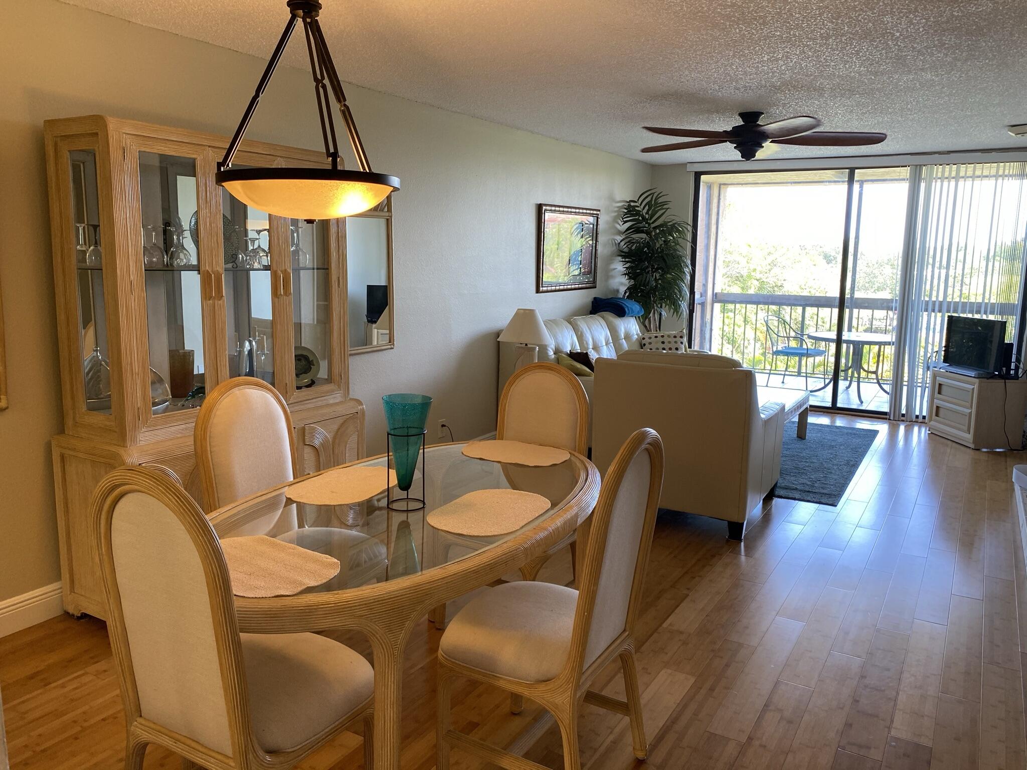 a dining room with furniture a chandelier and wooden floor