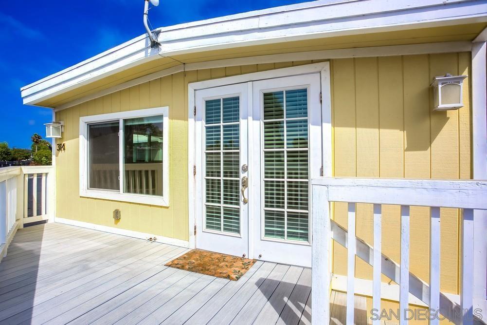 a view of front door of house with wooden floor and a window