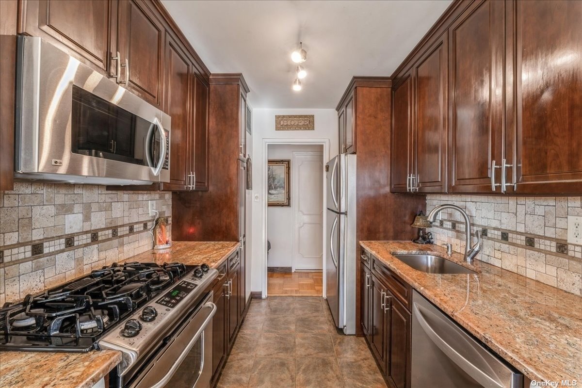 a kitchen with stainless steel appliances granite countertop a stove and a refrigerator