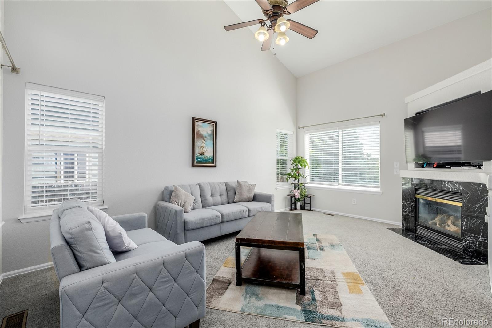 a living room with furniture a flat screen tv and a window