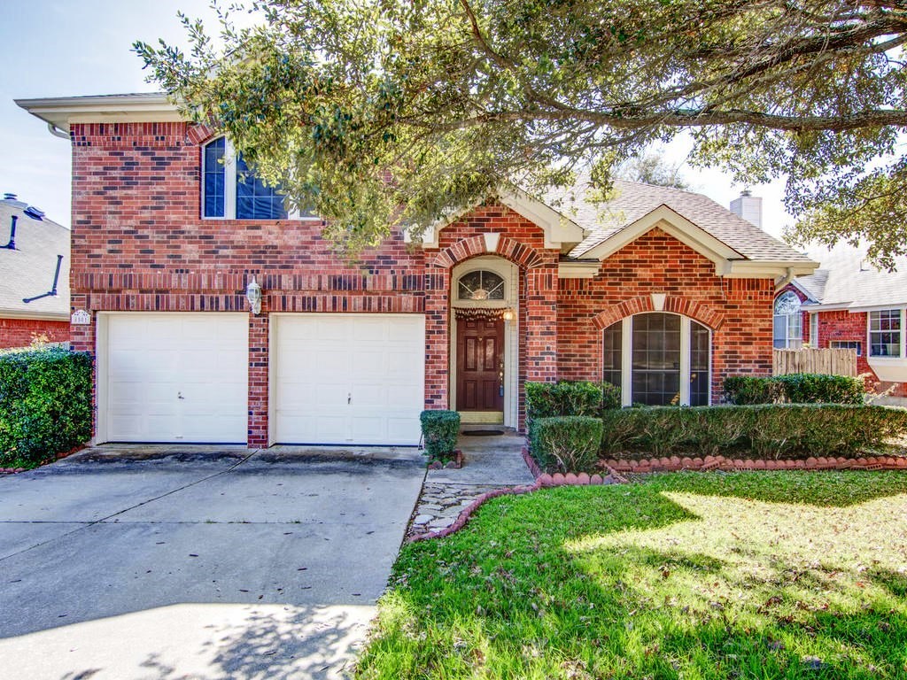 a front view of a house with a yard and garage