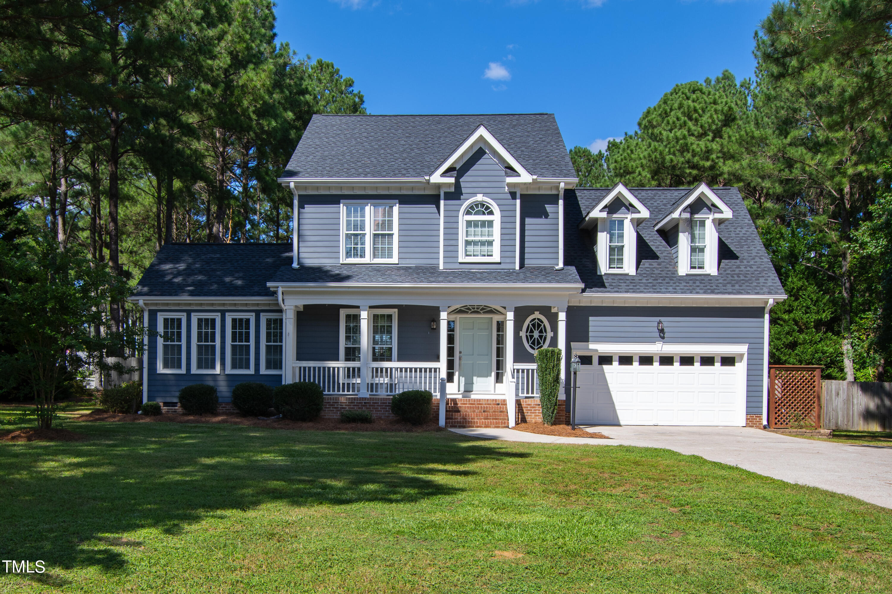 a front view of a house with a yard and trees