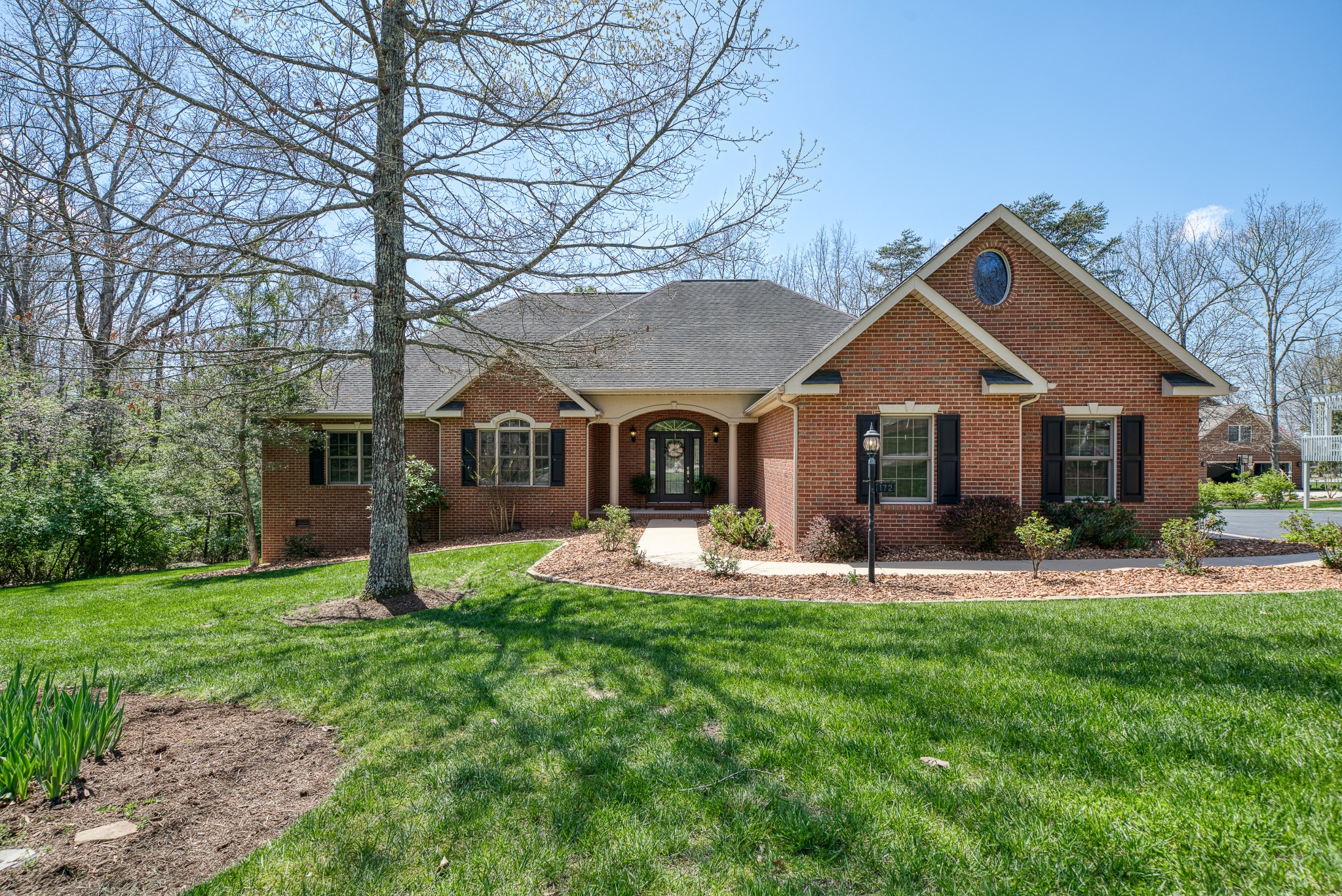 a front view of a house with a yard and trees