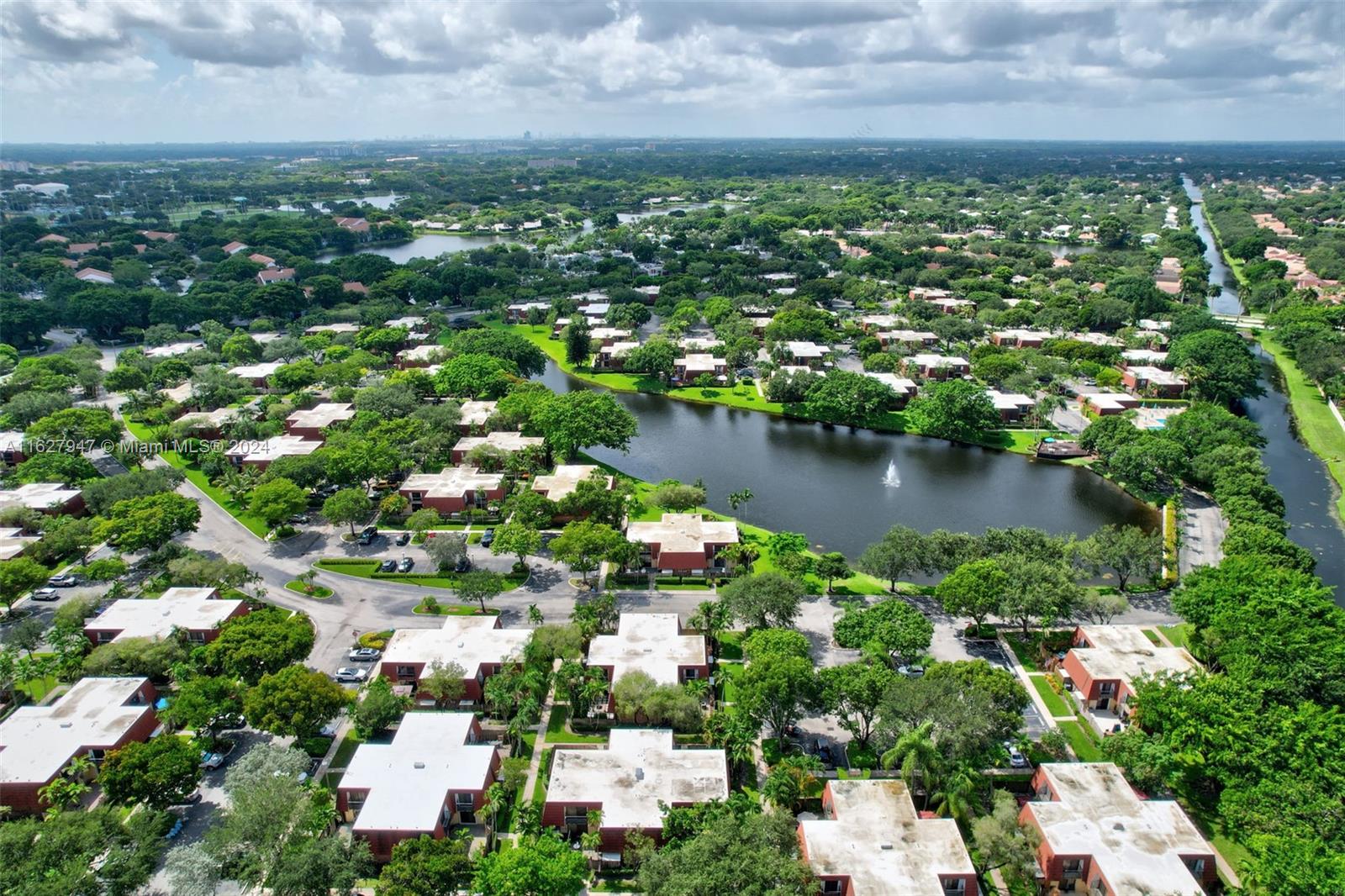 an aerial view of residential houses with outdoor space and lake view