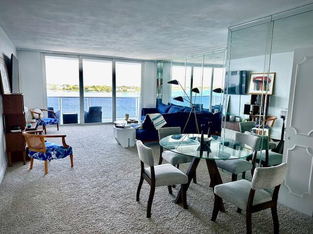 a living room with furniture kitchen view and large windows