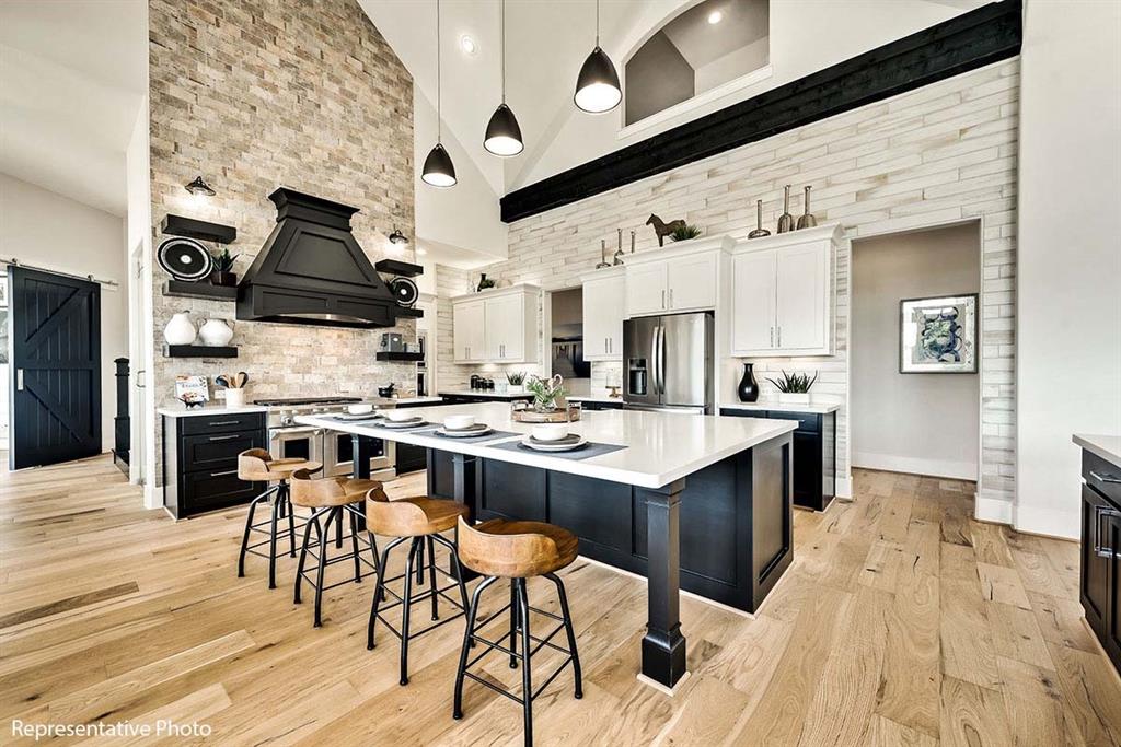 a kitchen with stainless steel appliances kitchen island granite countertop a table chairs in it and wooden floors