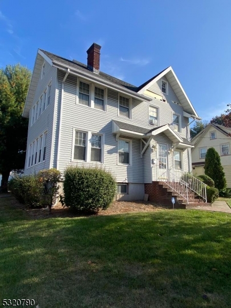 a front view of a house with a garden and plants