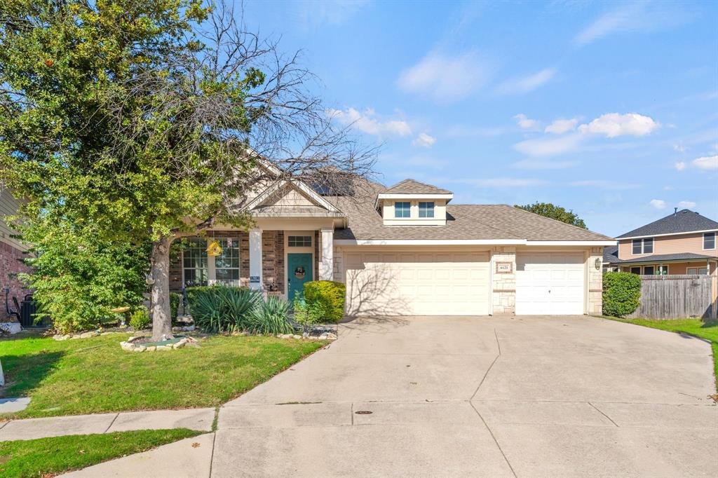 a front view of a house with a yard and trees