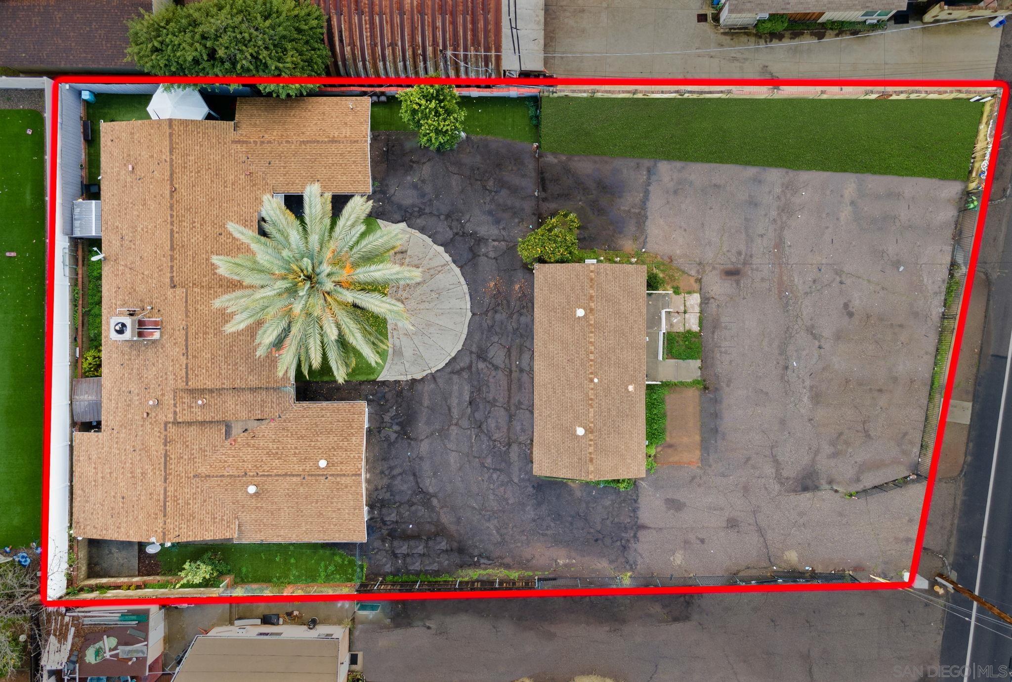 an aerial view of a house with a yard and large tree